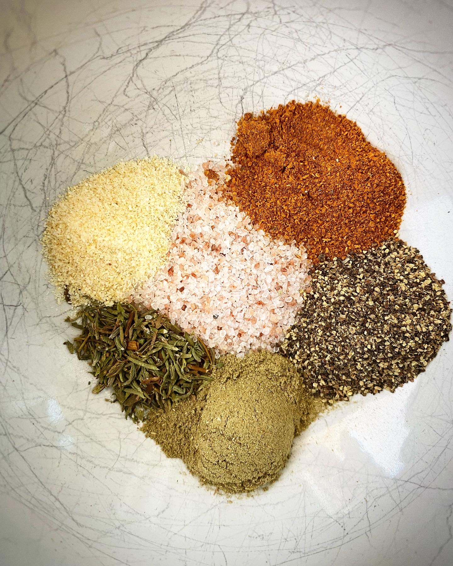 close up of homemade seasonings in a white bowl