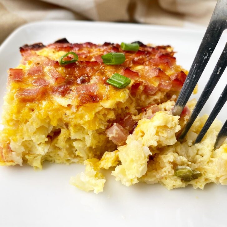 breakfast casserole on a white plate with a fork in it