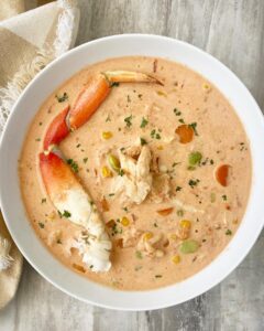 overhead shot of creamy crab soup in a white bowl