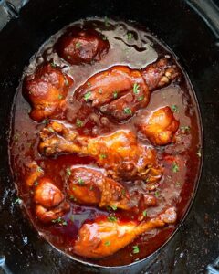 cooked bbq chicken drumsticks in a black crockpot
