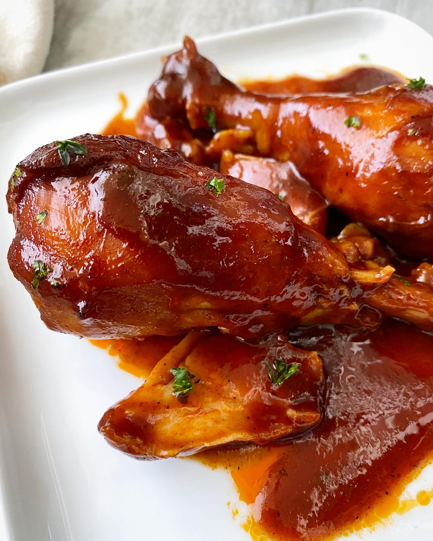 bbq chicken drumsticks on a white plate