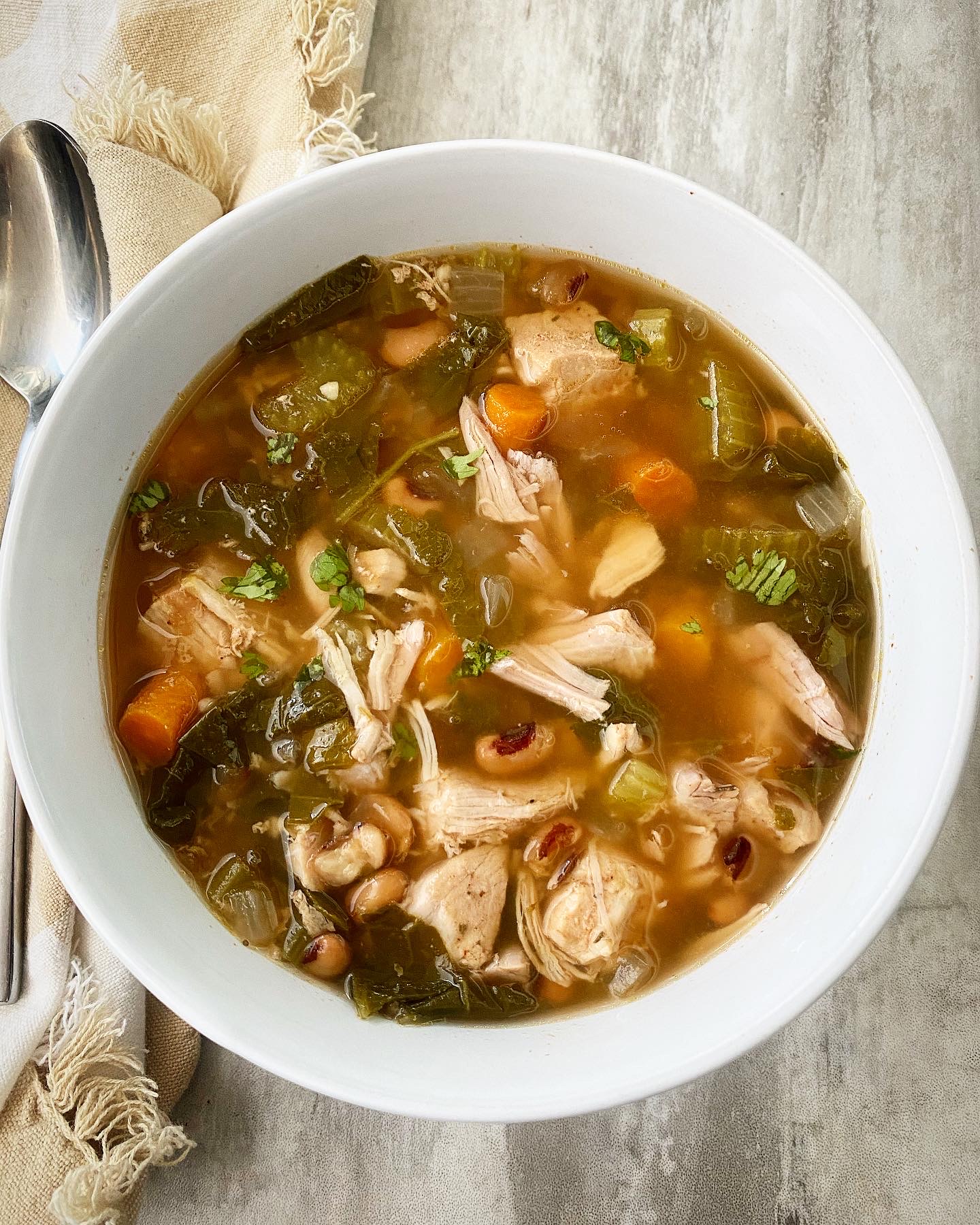 overhead shot of soul food soup in a white bowl