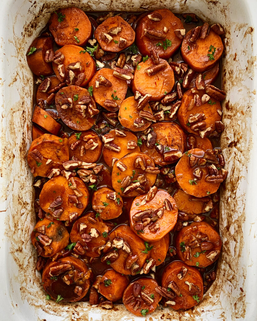 overhead shot of cooked crockpot sweet potato casserole in a white casserole shaped slow cooker