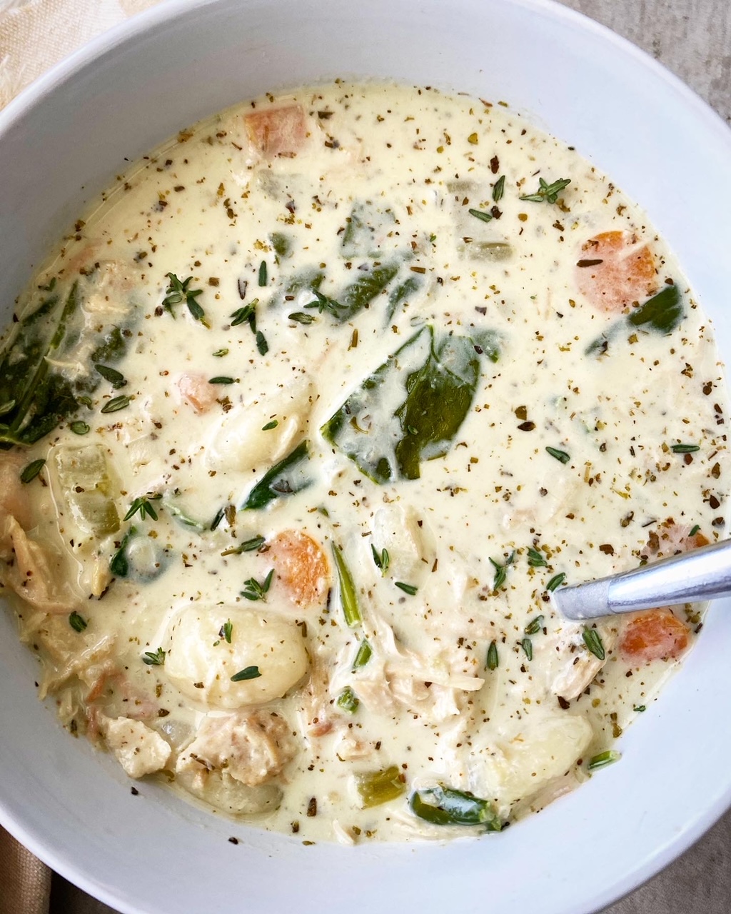 overhead shot of cooked Chicken Gnocchi Soup in a white bowl