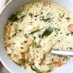 overhead shot of cooked Chicken Gnocchi Soup in a white bowl with a silver spoon in it