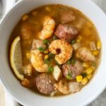 overhead shot of shrimp boil soup in a white bowl