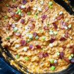overhead shot of bacon cheeseburger dip in a black slow cooker