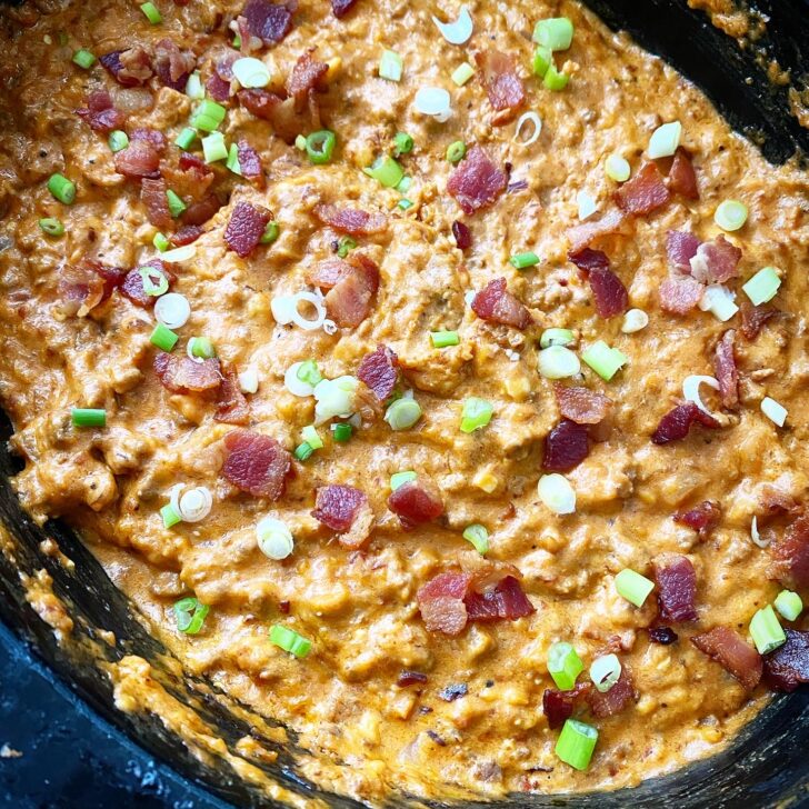 overhead shot of bacon cheeseburger dip in a black slow cooker