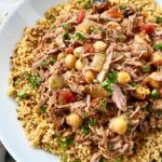 side view shot of slow cooker north African lamb in a white bowl garnished with parsley