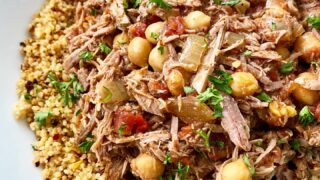 side view shot of slow cooker north African lamb in a white bowl garnished with parsley