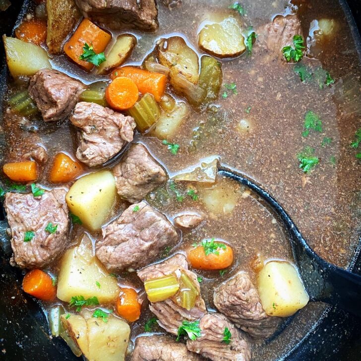 overhead shot of cooked Guinness beef stew in a black slow cooker