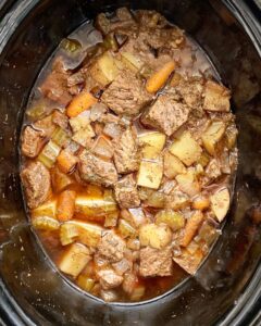 overhead shot of cooked Guinness beef stew in a black slow cooker