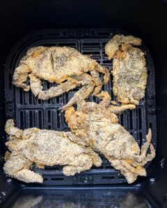 overhead shot of uncooked air fryer soft shell crab in a black air frye