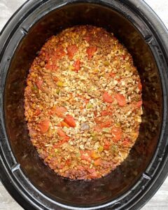 overhead shot of cooked ground beef spanish rice in a black slow cooker