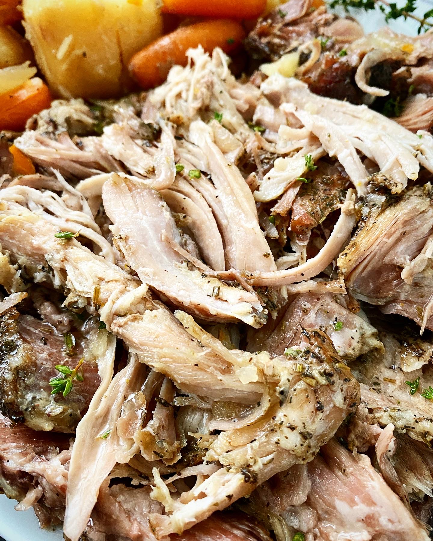 close up shot of cooked crockpot roast pork on a white plate
