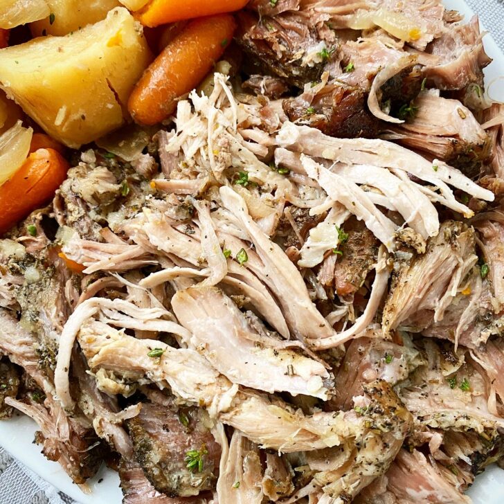 close up shot of cooked crockpot roast pork on a white plate