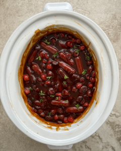 overhead shot of Cranberry BBQ Cocktail Sausages in a white slow cooker