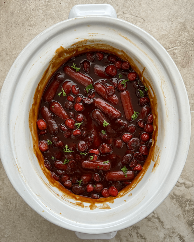 overhead shot of Cranberry BBQ Cocktail Sausages in a white slow cooker