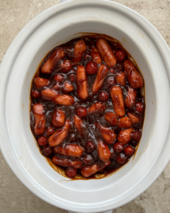 overhead shot of Cranberry BBQ Cocktail Sausages in a white slow cooker