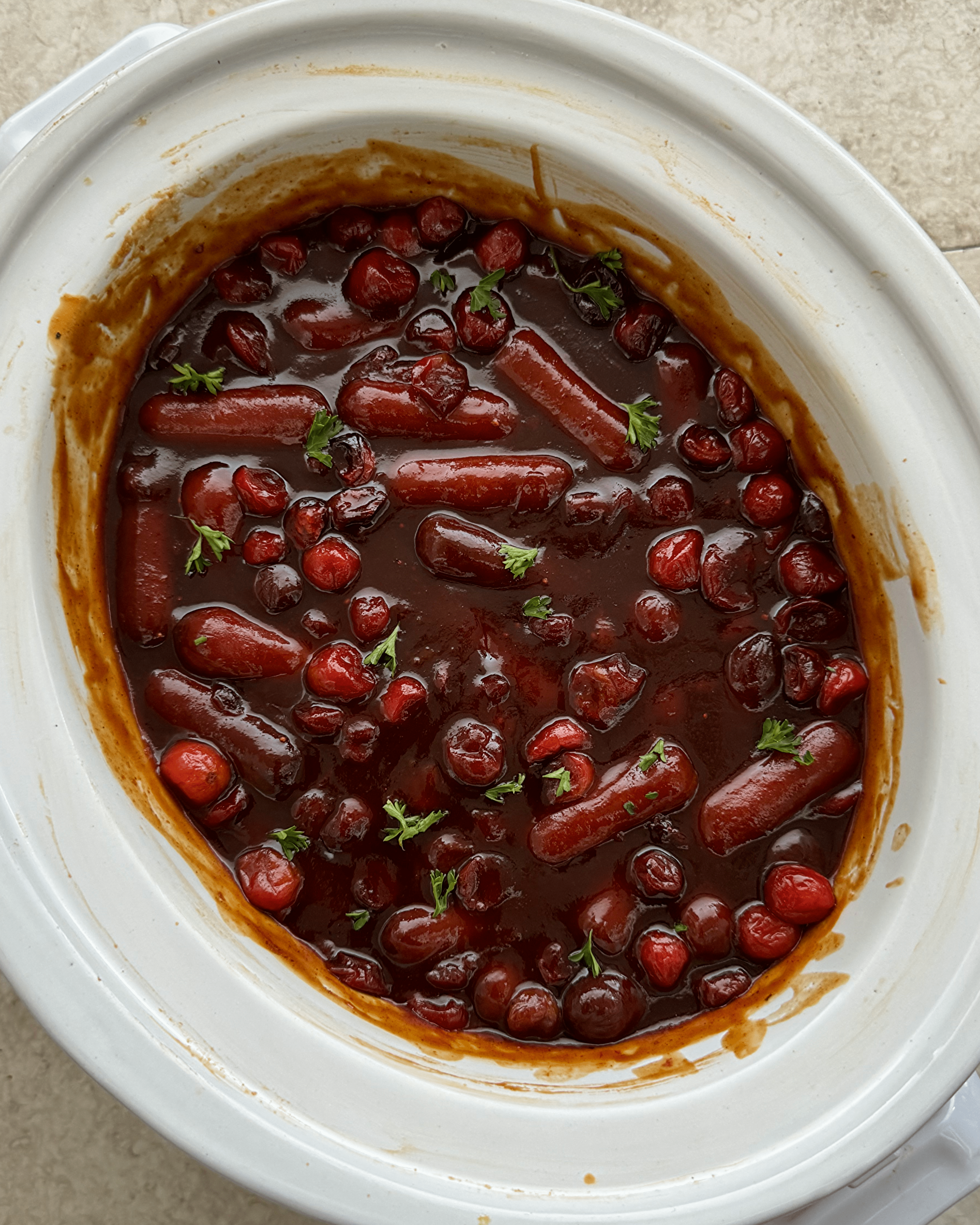 overhead shot of Cranberry BBQ Cocktail Sausages in a white slow cooker