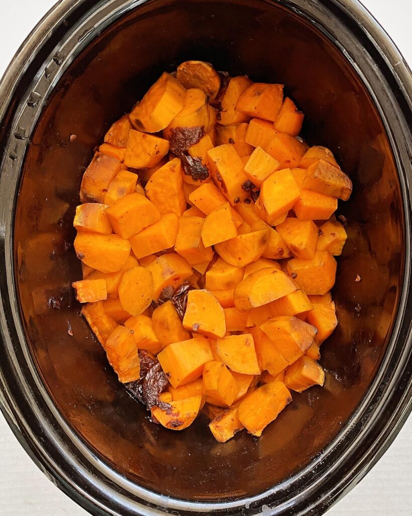 overhead shot of chipotle mashed sweet potatoes in a black slow cooker