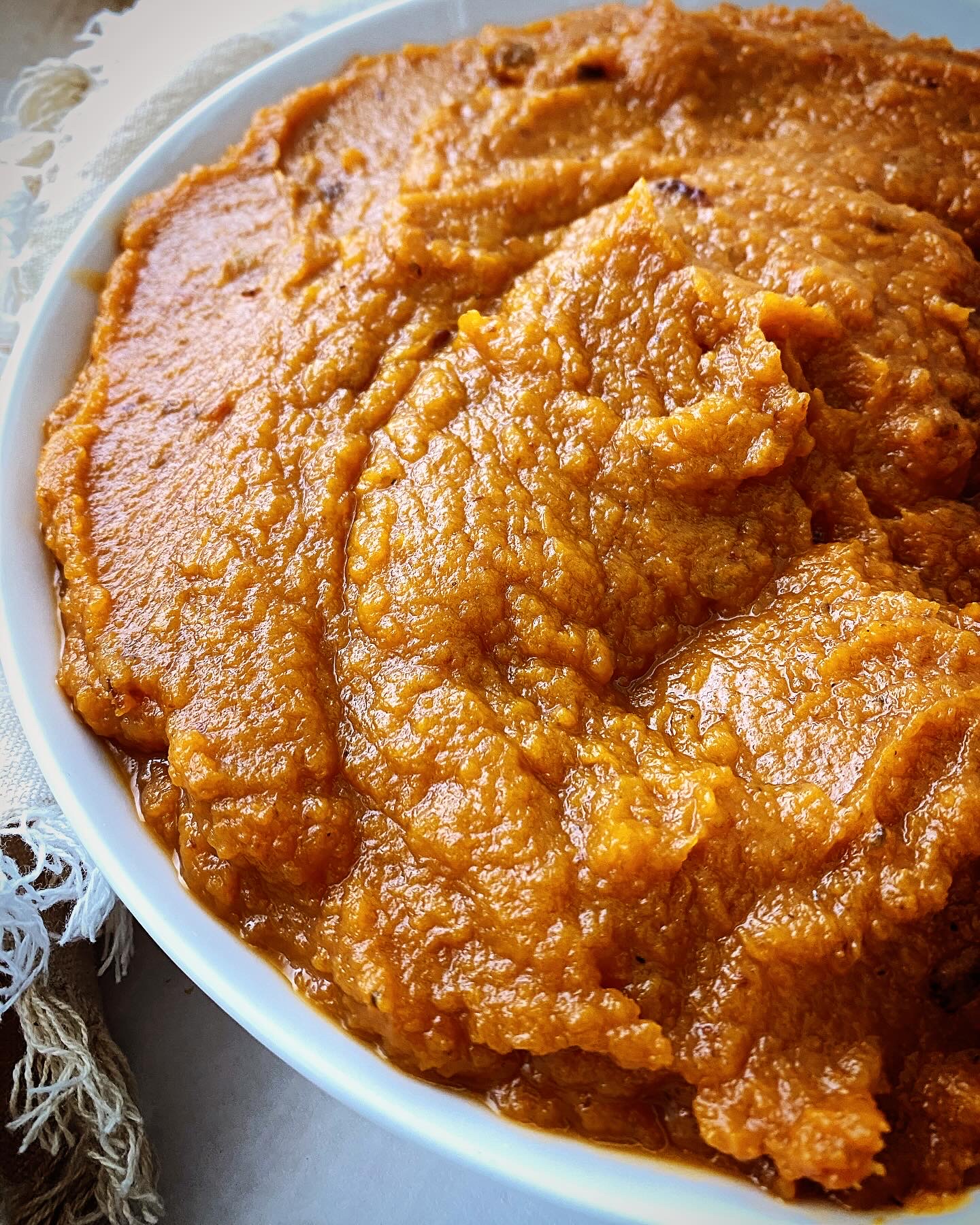 close up shot of chipotle mashed sweet potatoes in a white bowl