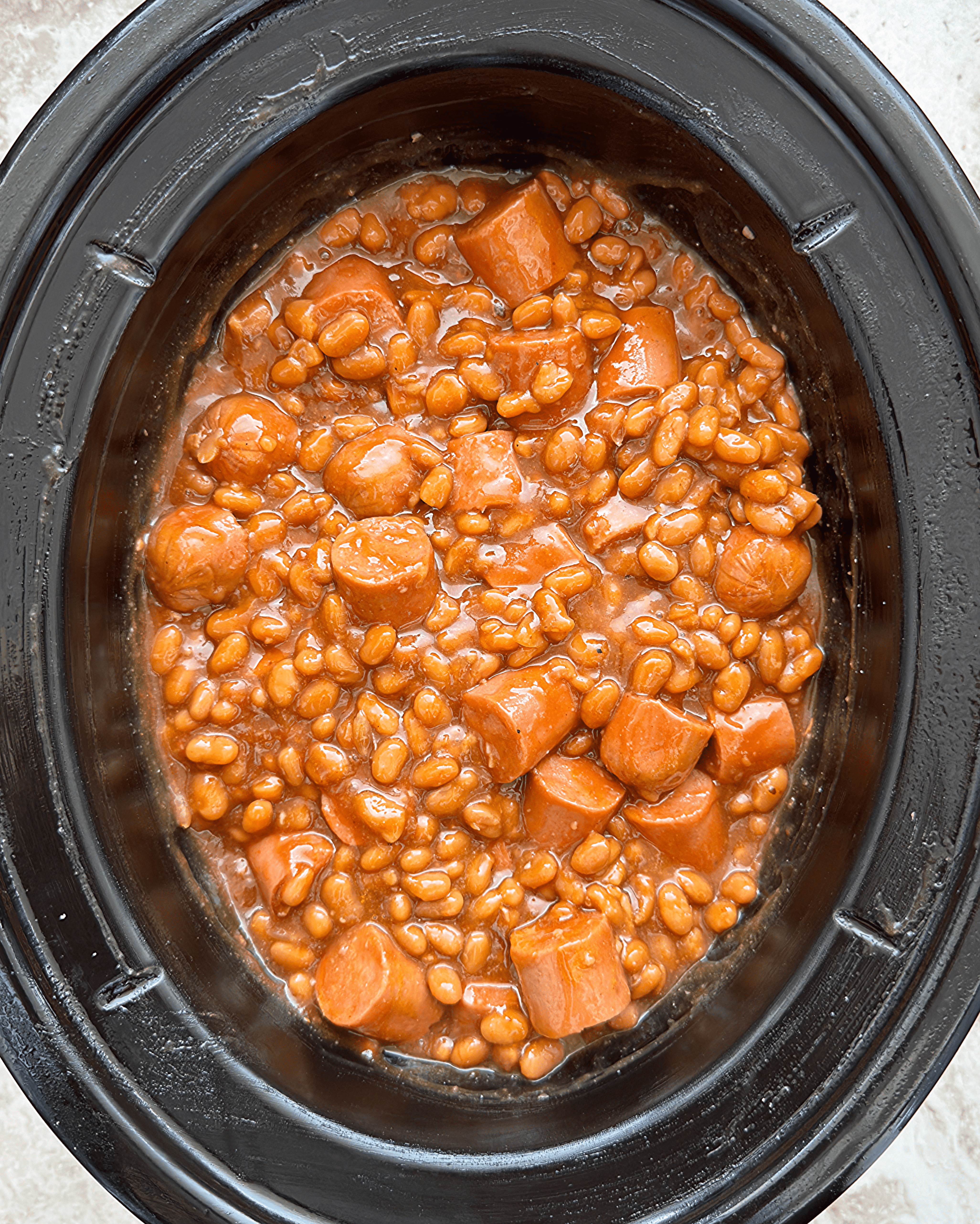 overhead shot of cooked beans and franks