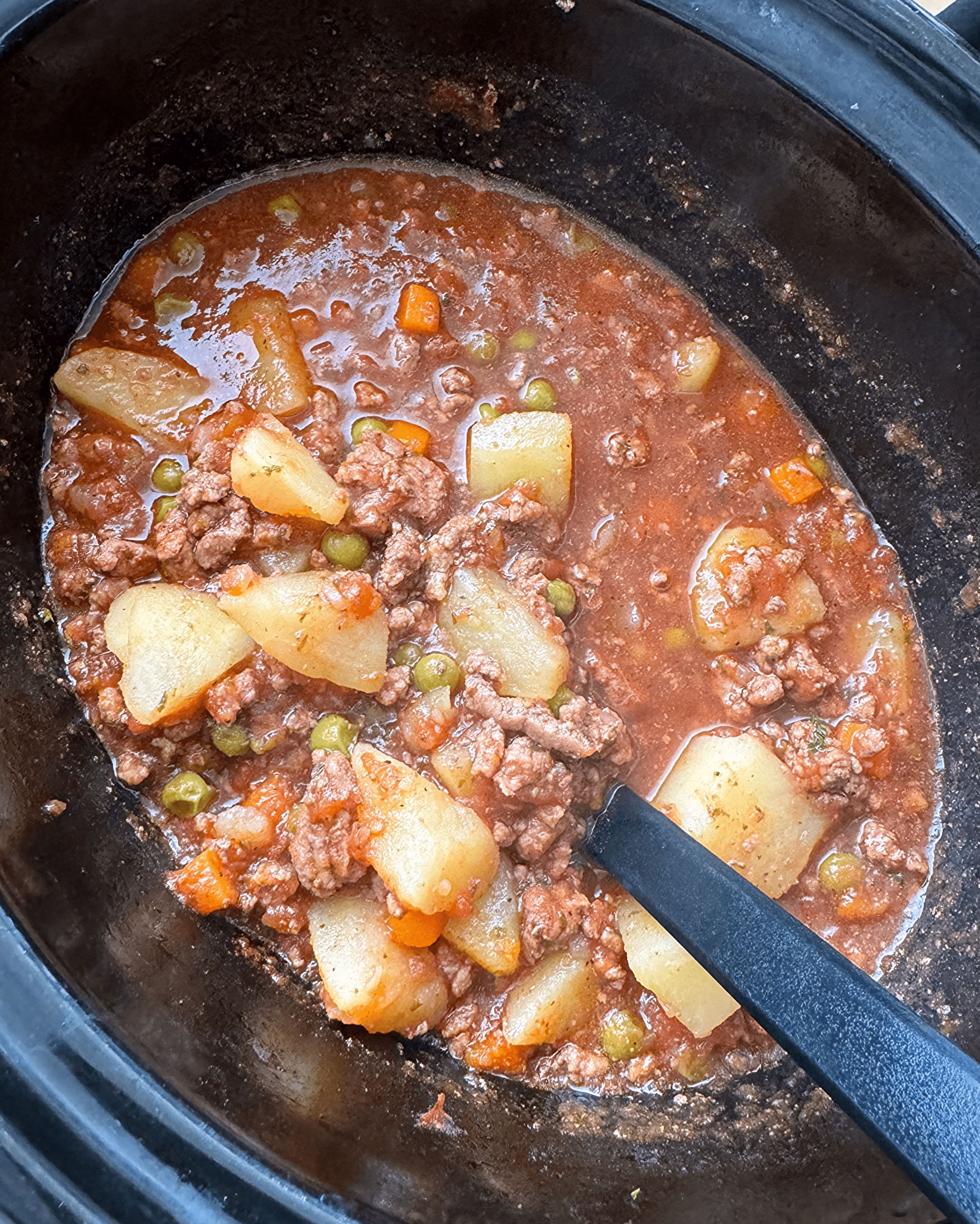 close up shot of uncooked poor man's stew in a black slow cooker