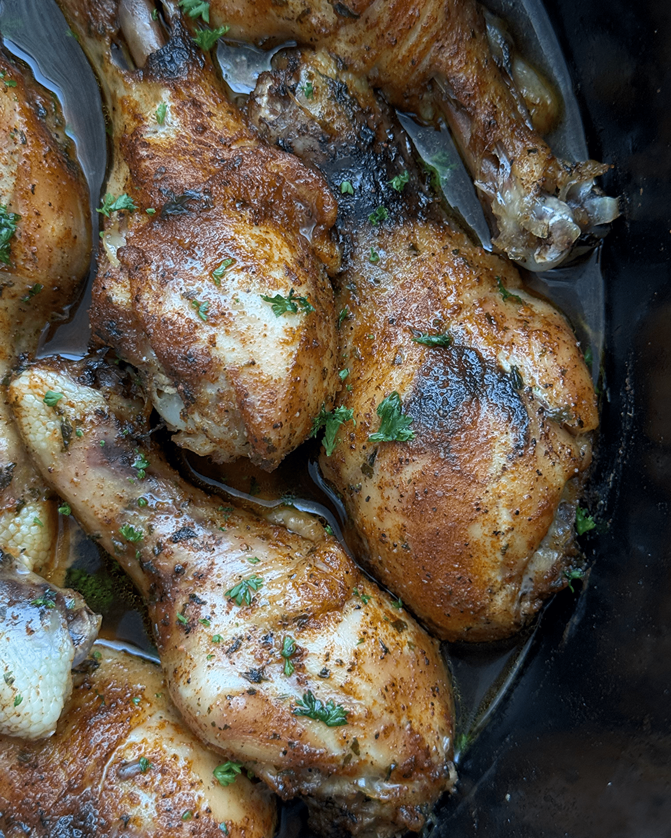 close up shot of cooked chicken legs in a black slow cooker
