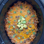 close up shot of beef taco casserole garnished with fresh cilantro and diced avocado