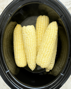 overhead shot of cooked corn in a black slow cooker