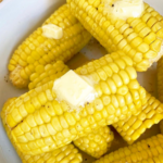 close up shot of cooked corn on the cob with butter, salt, and pepper