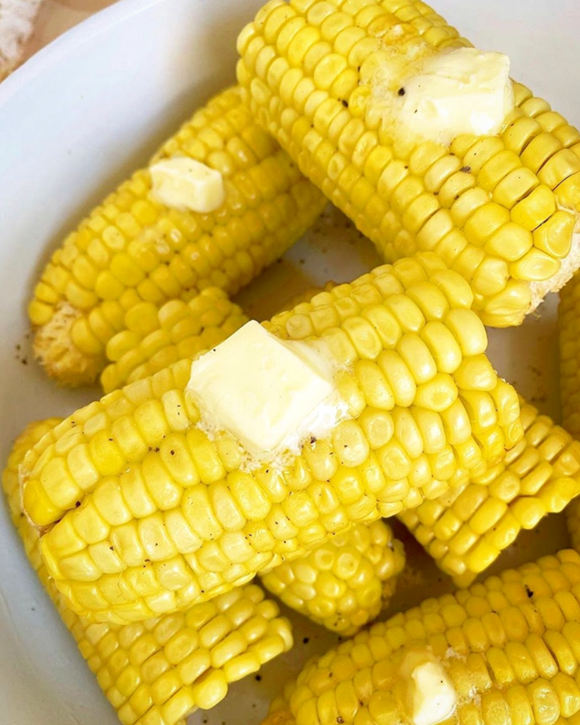 close up shot of cooked corn on the cob with butter, salt, and pepper