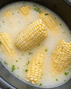 overhead shot of cooked milk boiled corn in a black slow cooker