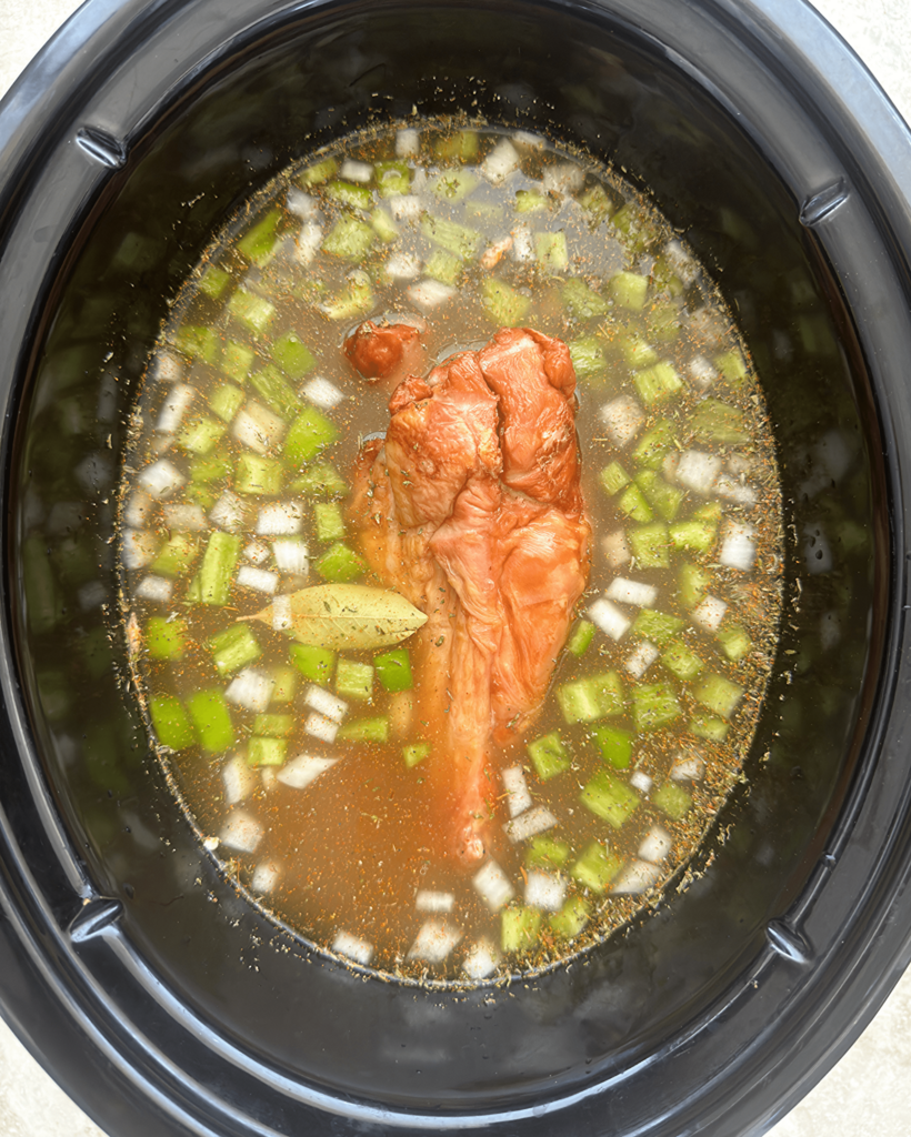 overhead shot of uncooked Slow Cooker Southern Pinto Beans with smoked turkey in a black slow cooker