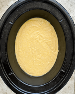 overhead shot of uncooked Cornbread in a black slow cooker