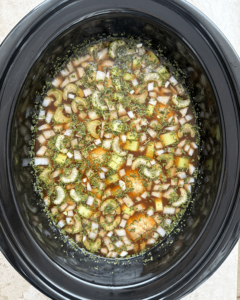 overhead shot of uncooked Meatball Tortellini Soup in a black slow cooker