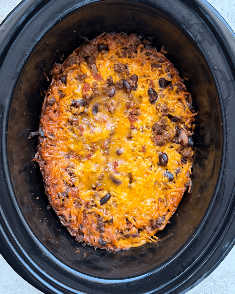 overhead shot of cooked chili casserole in a black slow cooker