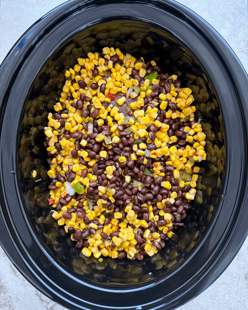 overhead shot of uncooked tex mex beef roast in a black slow cooker