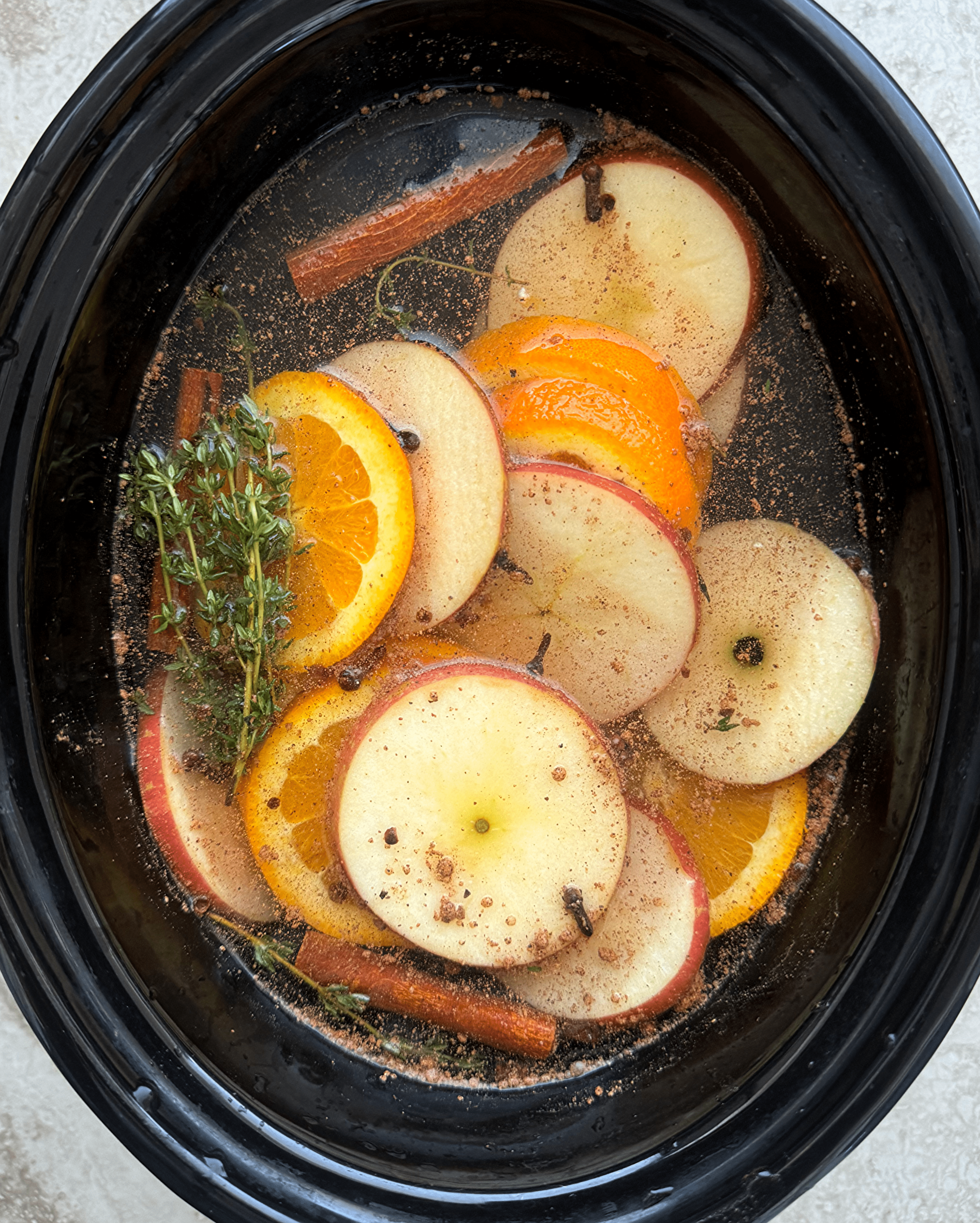 overhead shot of uncooked Fall Potpourri in a black slow cooker
