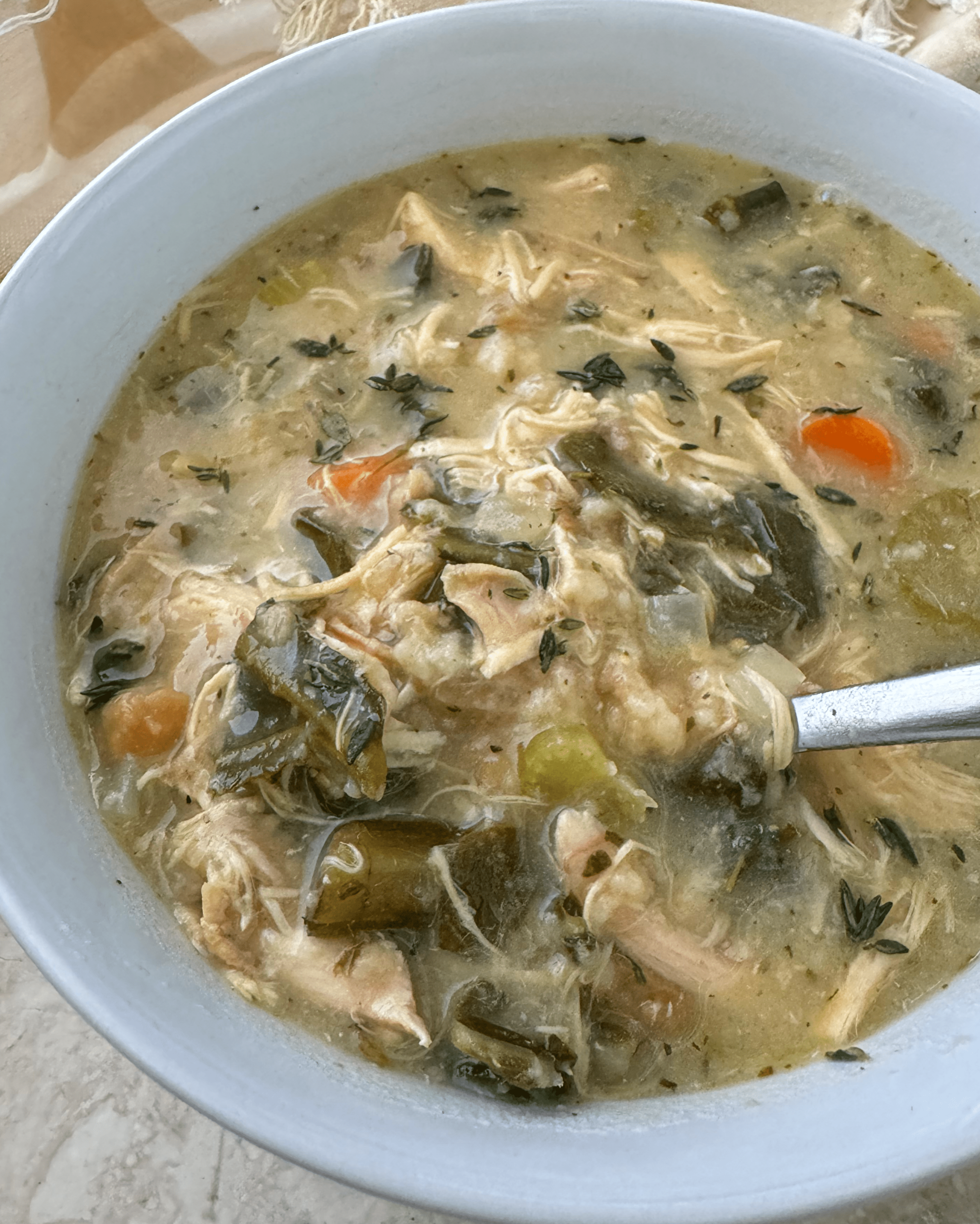 overhead shot of Crockpot Leftover Holiday Soup in a white bowl with a spoon 
