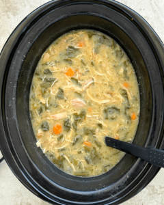 overhead shot of cooked Leftover Holiday Soup in a black slow cooker