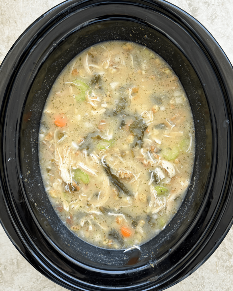 overhead shot of uncooked Leftover Holiday Soup in a black slow cooker