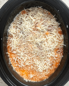 overhead shot of cooked ravioli casserole in a black slow cooker