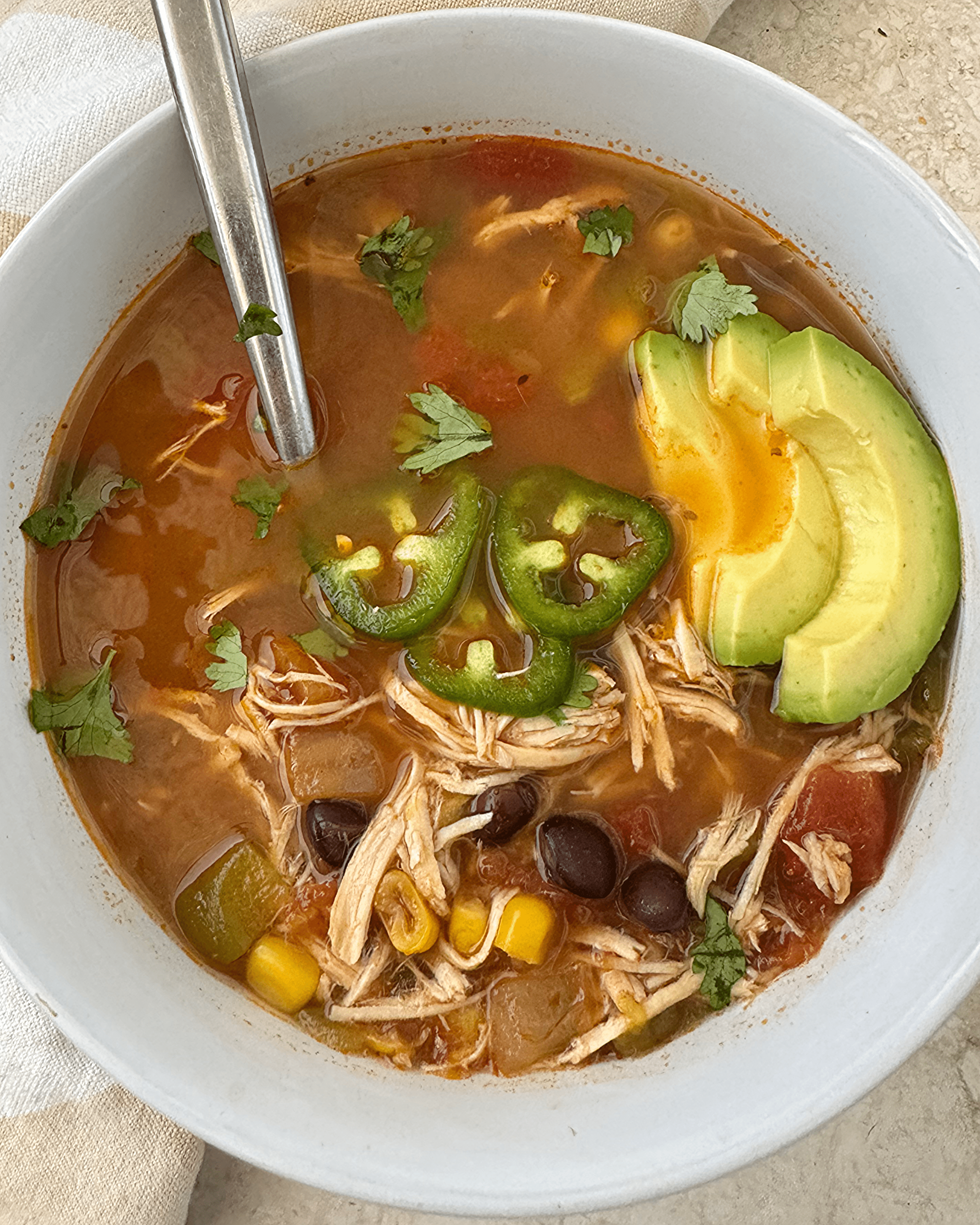close up shot of chicken taco soup in a white bowl