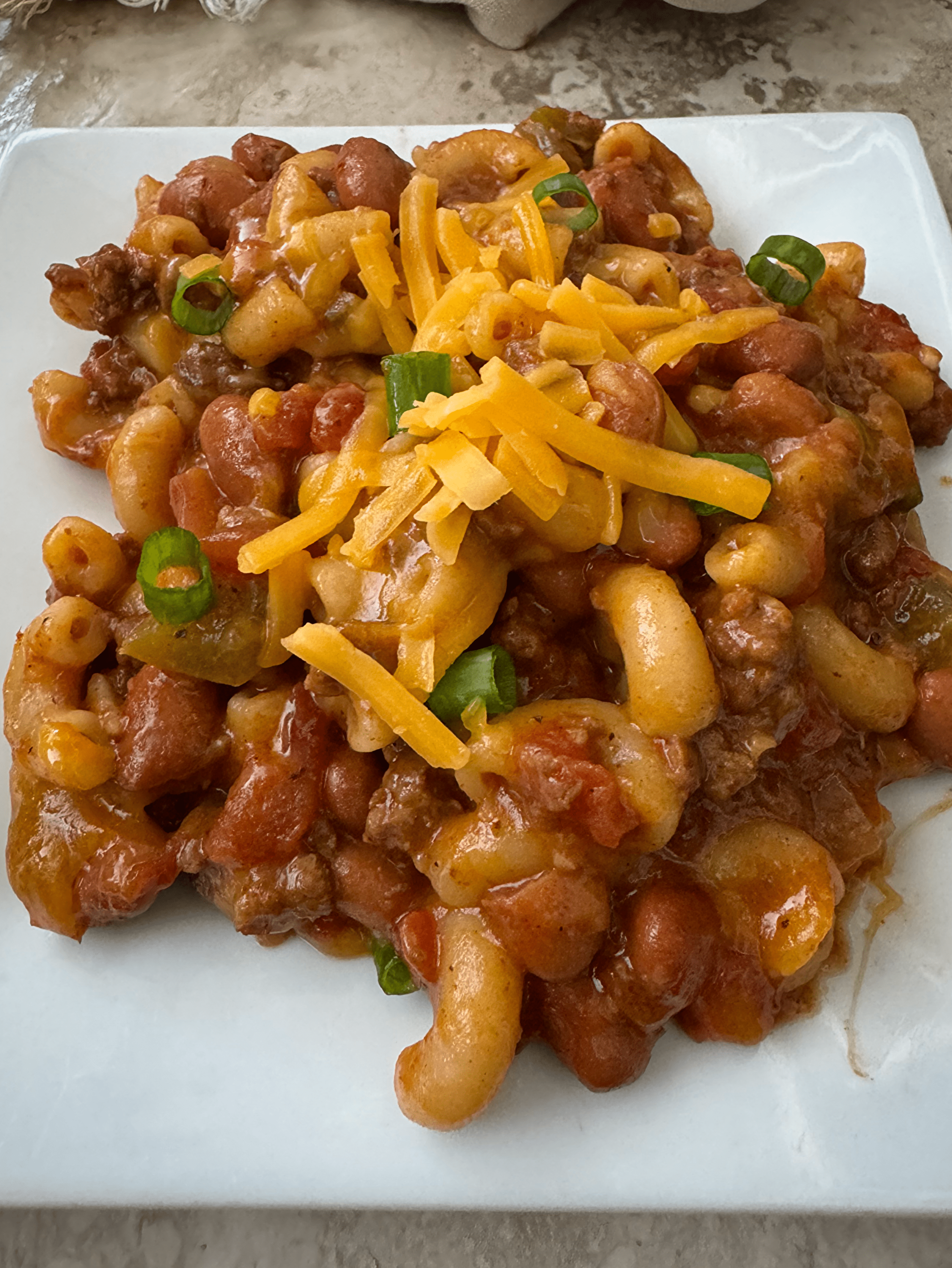 close up shot of cooked Chili Mac And Cheese on a white plate