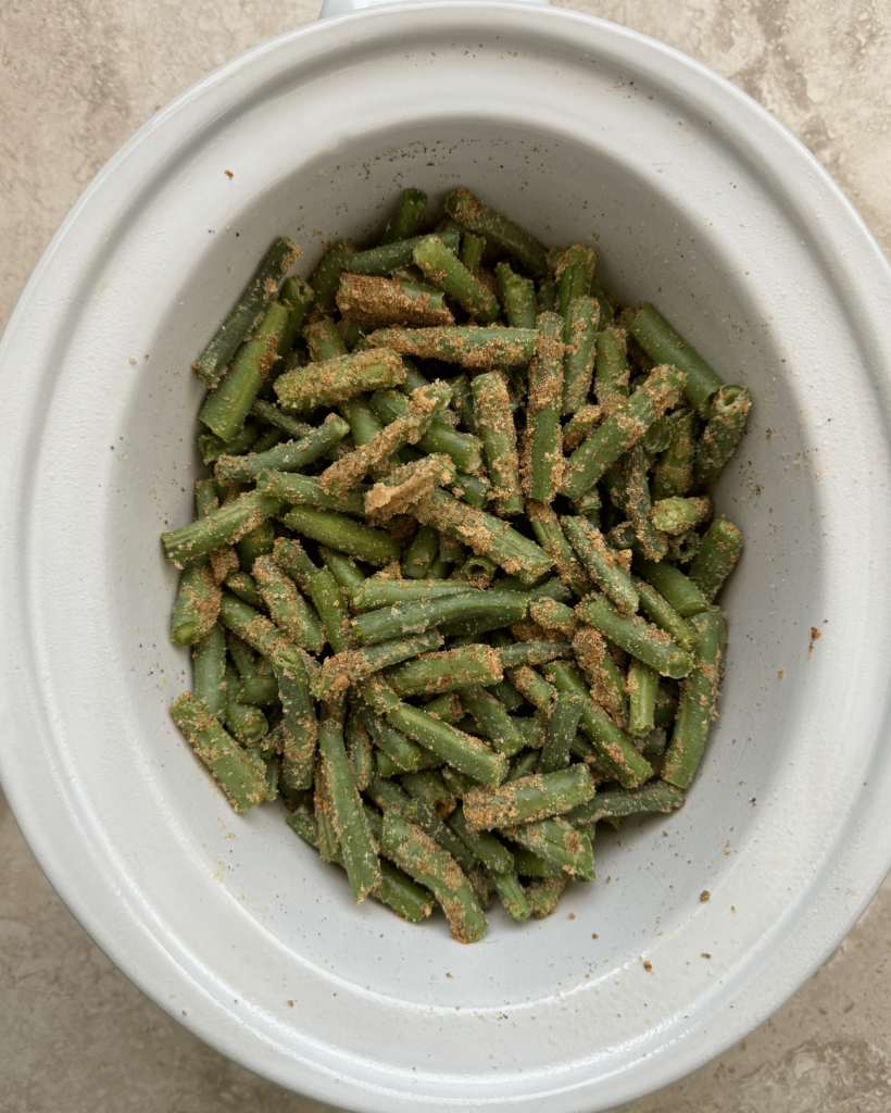overhead shot of uncooked crockpot Green Beans in a white slow cooker