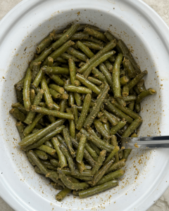 overhead shot of cooked crockpot Green Beans in a white slow cooker