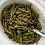 overhead shot of cooked crockpot Green Beans in a white slow cooker