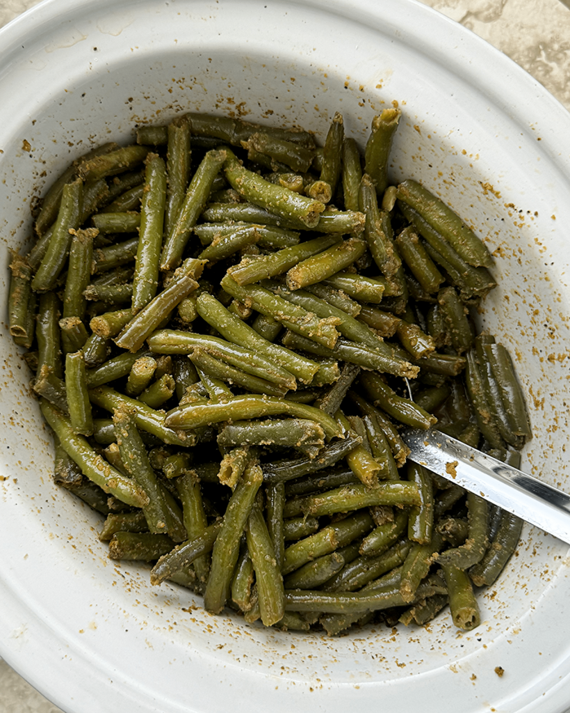 overhead shot of cooked crockpot Green Beans in a white slow cooker
